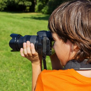 10779379 - kid taking shots with photocamera in park